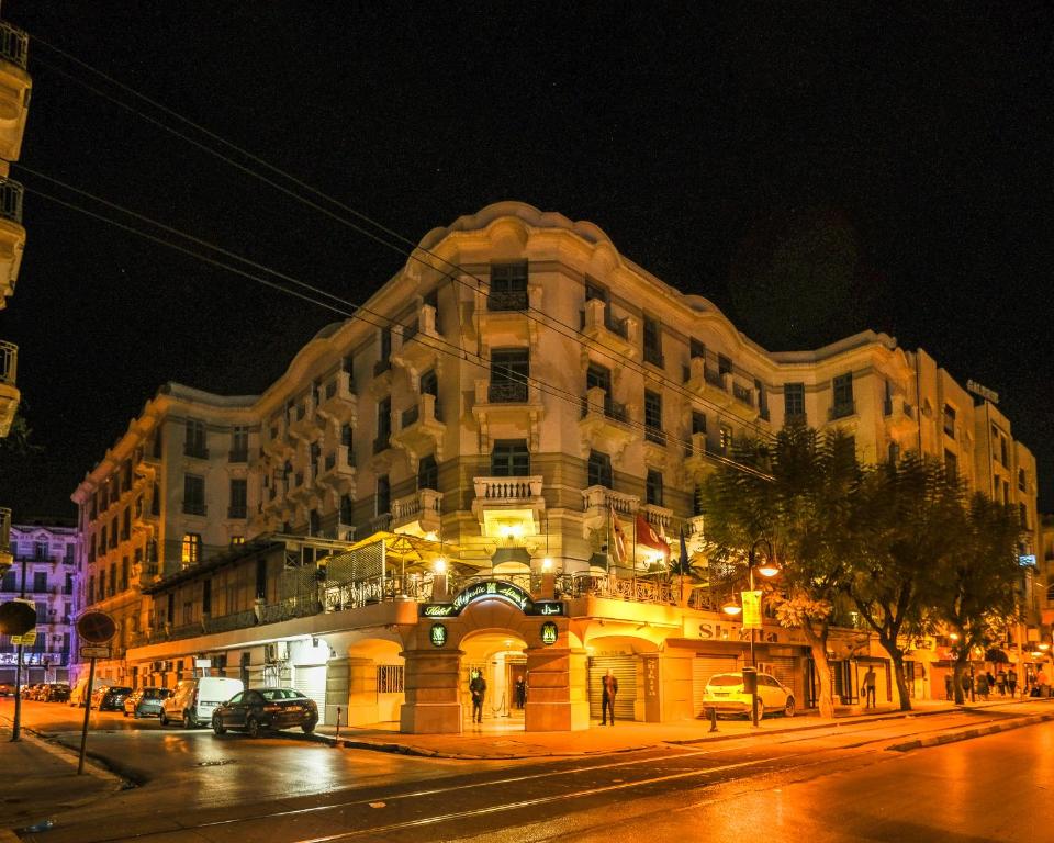 un grand bâtiment situé dans une rue de la ville la nuit dans l'établissement Majestic Hotel, à Tunis