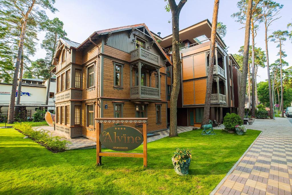 une grande maison avec un panneau en face de celle-ci dans l'établissement Villa Alvīne Family Apart-Hotel, à Jurmala