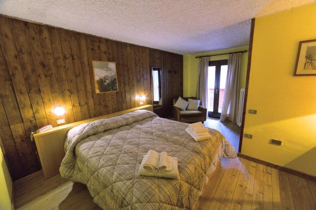 1 dormitorio con 1 cama con 2 toallas en Hotel Gran Baita, en Folgarida