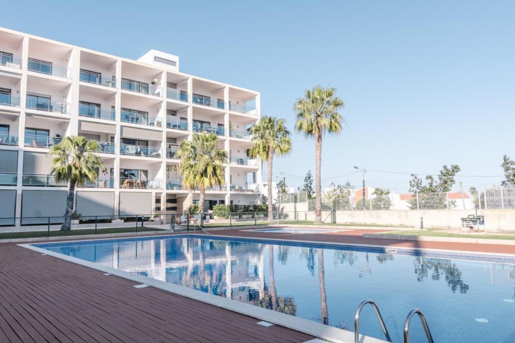 uma piscina em frente a um edifício em Casas de Mar - Barra Mar em Olhão