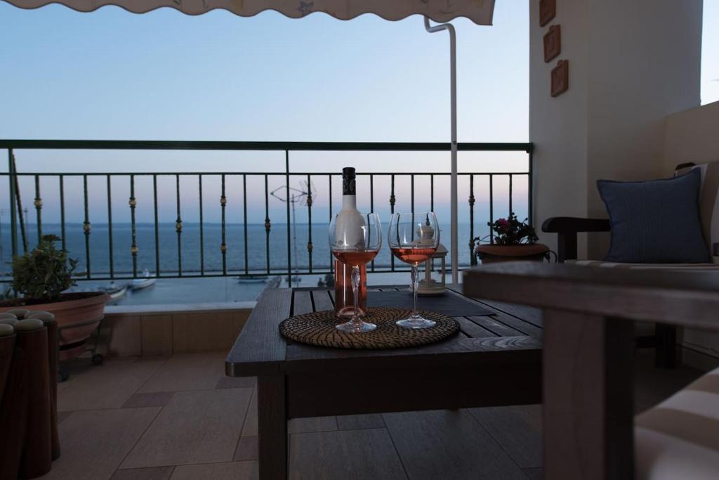 una mesa con dos copas y una botella de vino en Apartment with marina view, en Tesalónica