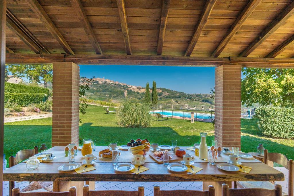 un tavolo con cibo e una vista su un cortile di The Grapevine by MANVI a Montepulciano