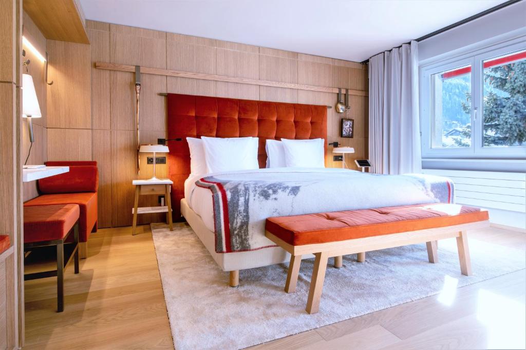 a bedroom with a large bed and a red headboard at Schweizerhof Zermatt - a Small Luxury Hotel in Zermatt