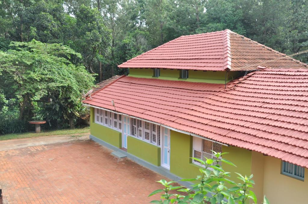 a house with a red roof at Thanmaya Homestay in Chikmagalūr