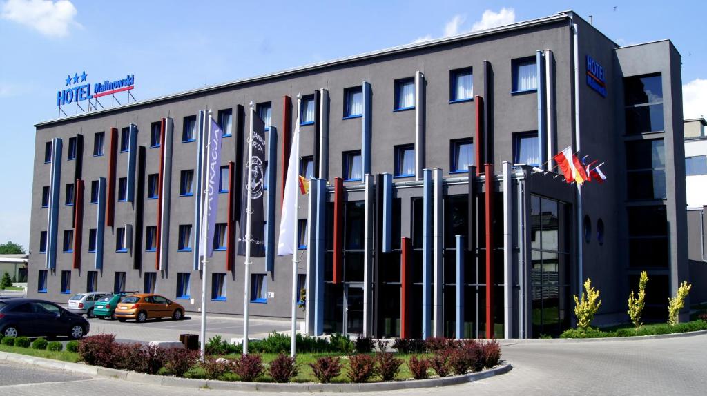 een groot gebouw met vlaggen ervoor bij Hotel Malinowski Business in Gliwice