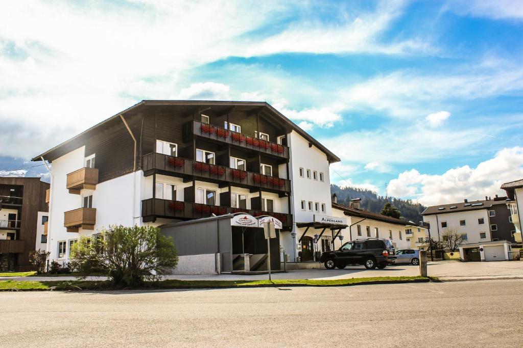 een gebouw waar een auto voor geparkeerd staat bij Hotel Alpenland in Wattens