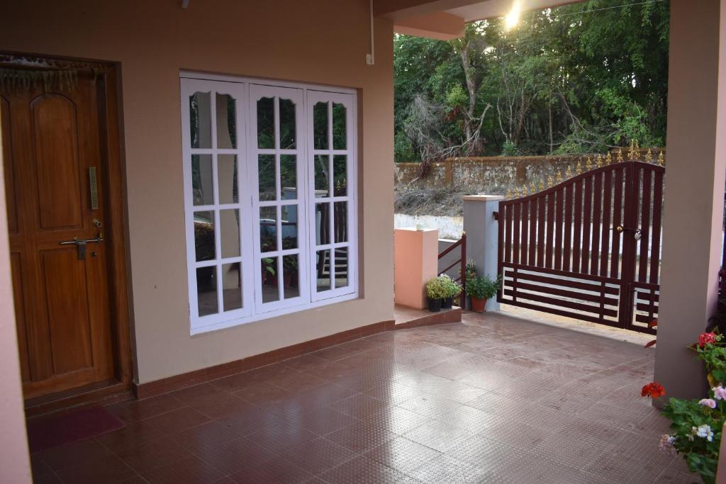 une terrasse avec une porte blanche et un escalier. dans l'établissement Srishti Homestay, à Madikeri