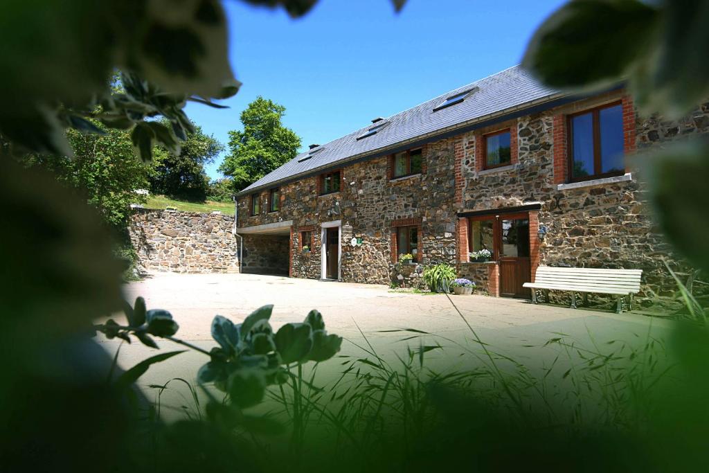 um edifício de tijolos com um banco à frente em Ferme Hurlet em Stavelot