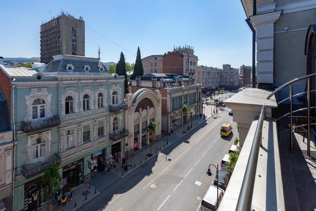 uma rua da cidade com edifícios e um táxi amarelo em Hotel Avenue 106 em Tbilisi