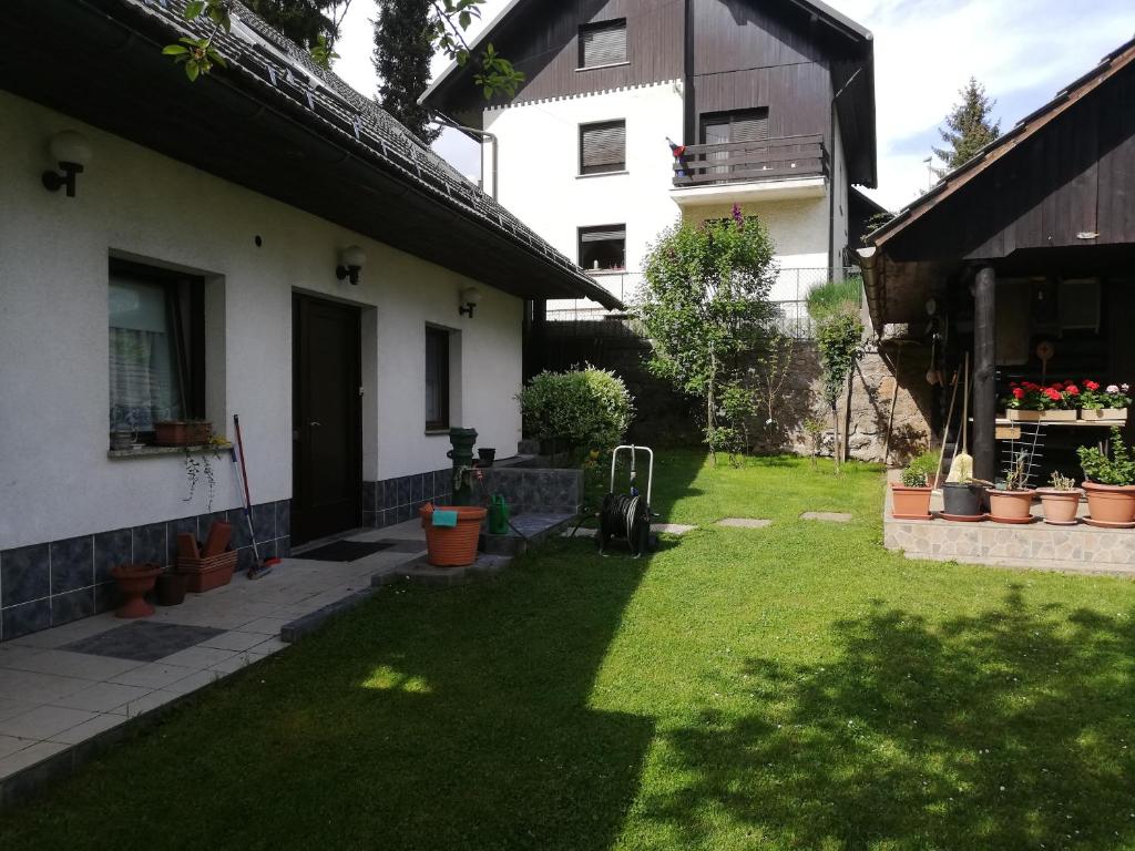 a backyard of a house with a yard with green grass at Apartment Sopar in Škofja Loka