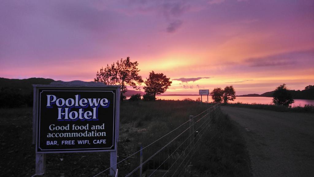 un cartello per un hotel su una strada con tramonto di Poolewe Hotel a Poolewe