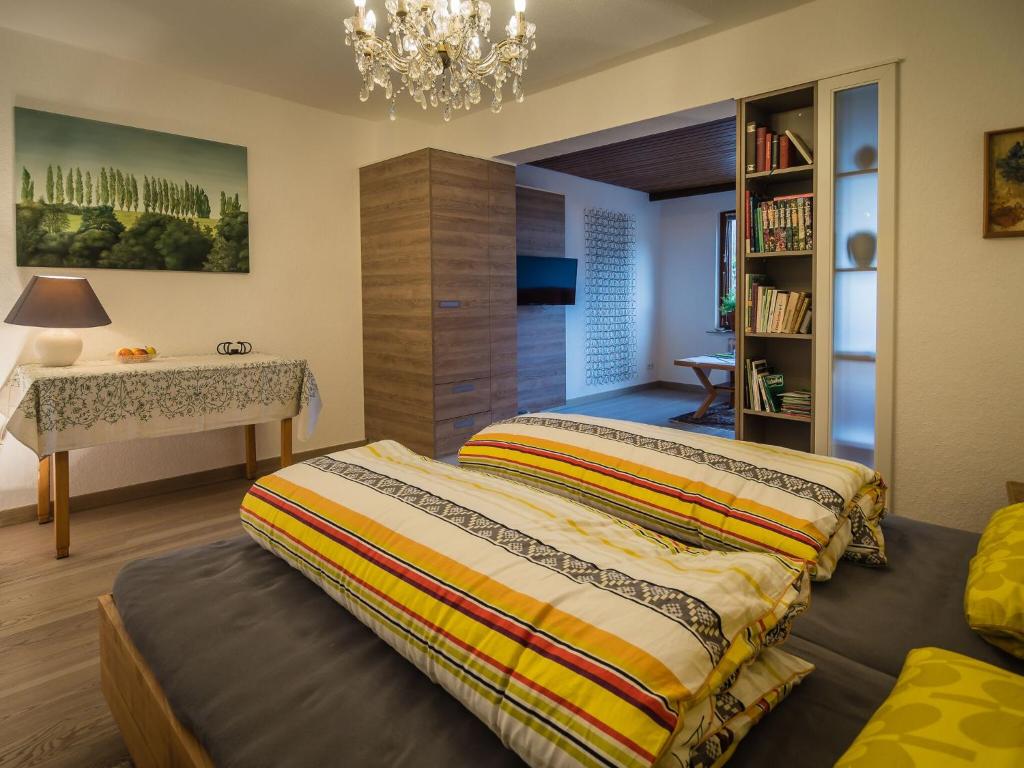 een slaapkamer met 2 bedden, een bureau en een kroonluchter bij Antel 42 in Andernach