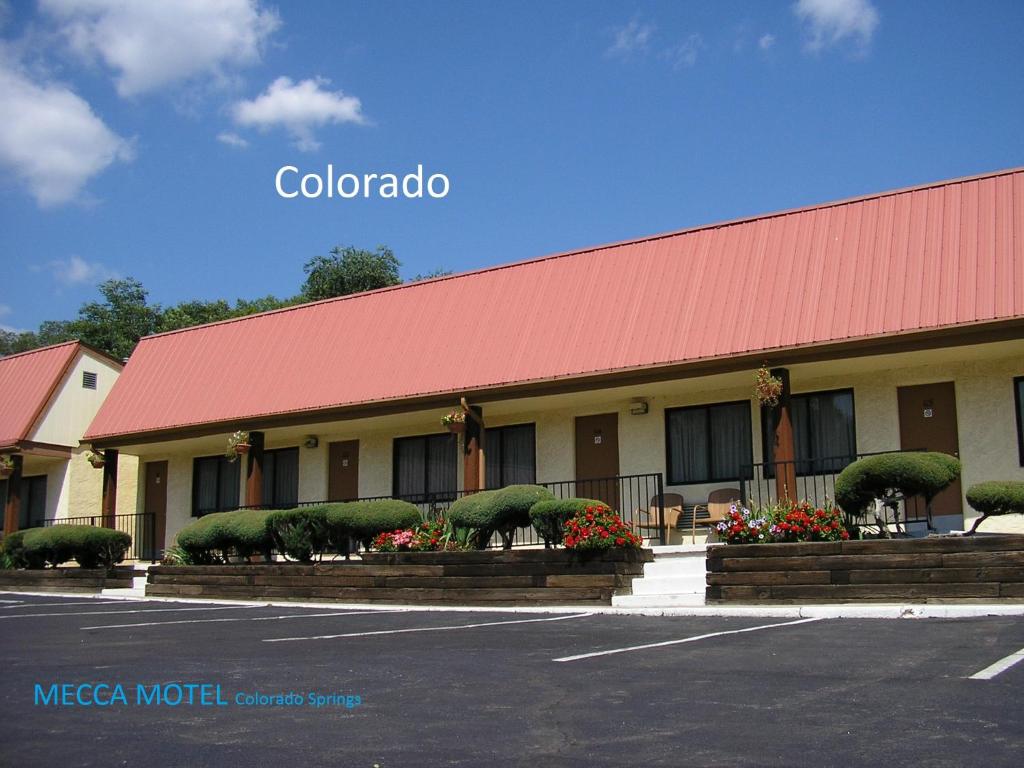 a colombo motel with a red roof and a parking lot at Mecca Motel in Colorado Springs