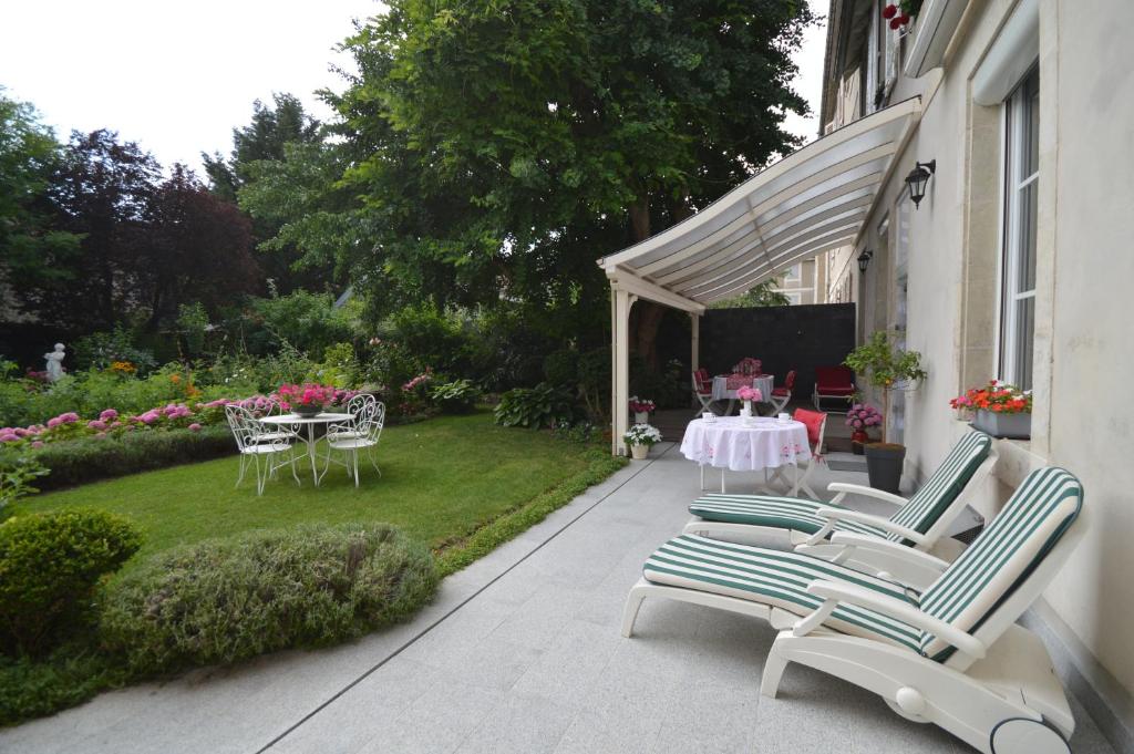 un patio con sedie e tavolo e un giardino di Chambre d'hôtes à TOUL centre ville avec parking privé a Toul