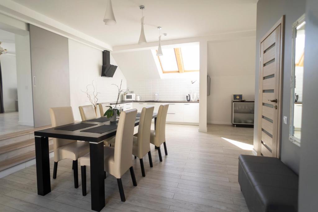 a dining room and kitchen with a black table and chairs at Svečių namai Lanko g. in Klaipėda