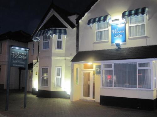 un edificio con un cartel delante de él por la noche en Warwick Lodge, en Kingston upon Thames