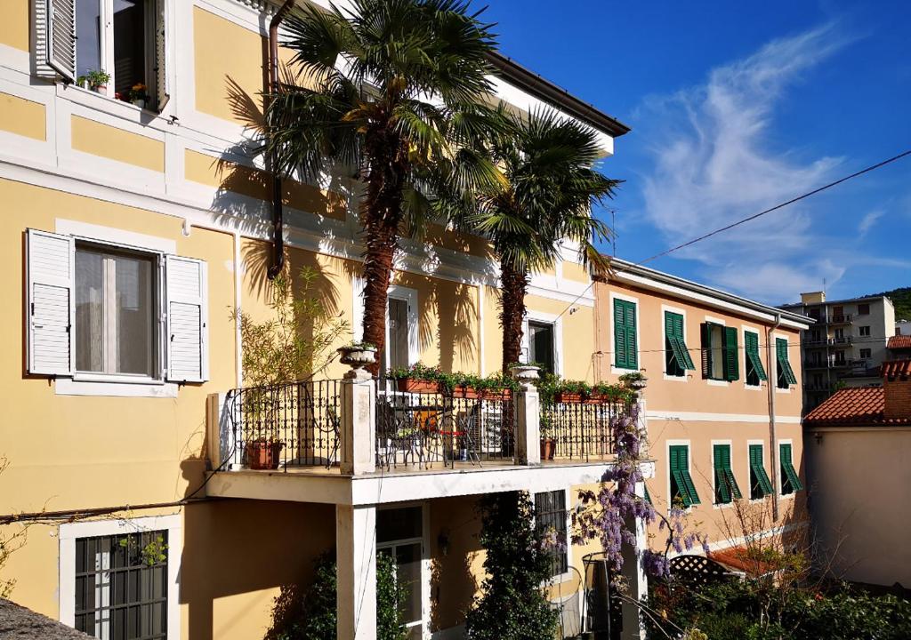 un bâtiment avec un balcon et un palmier dans l'établissement Le Palme Trieste, à Trieste