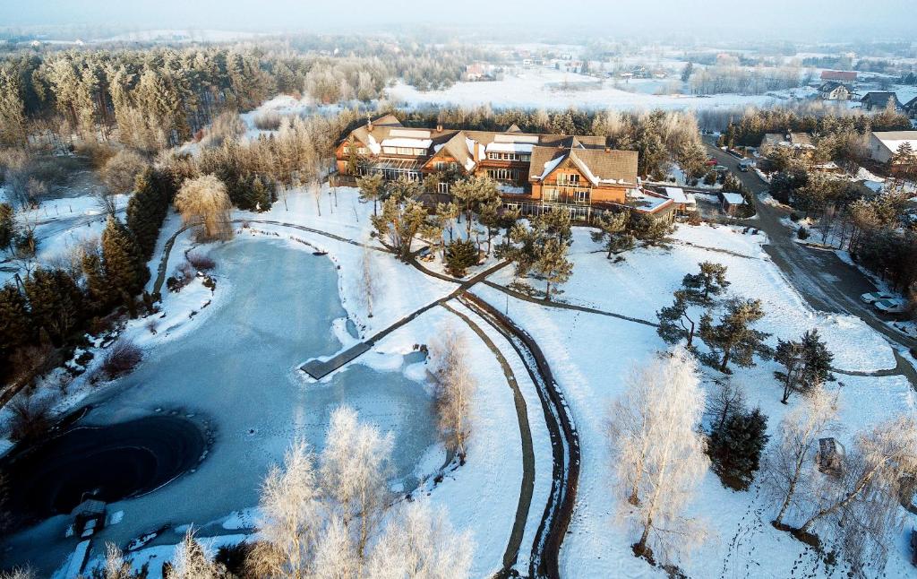 - une vue aérienne sur une maison dans la neige dans l'établissement HOTEL KOZI GRÓD Pokoje i Domki na Kaszubach, à Pomlewo