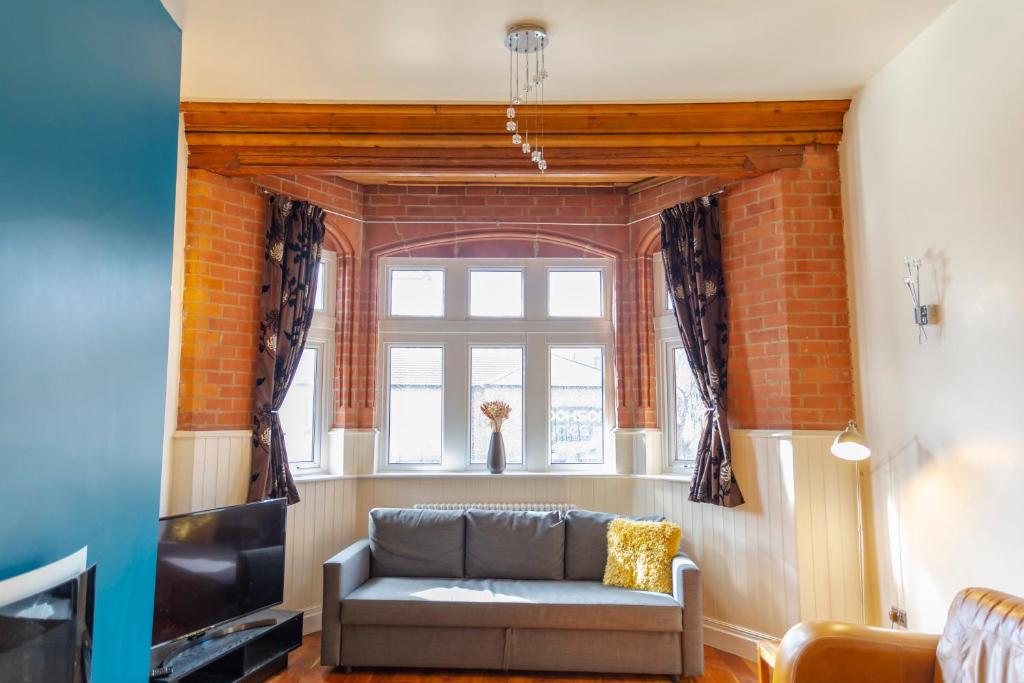 sala de estar con sofá y ventana en Apartment No 1 - The Old Red King Pub, Whitefield, Manchester, en Mánchester