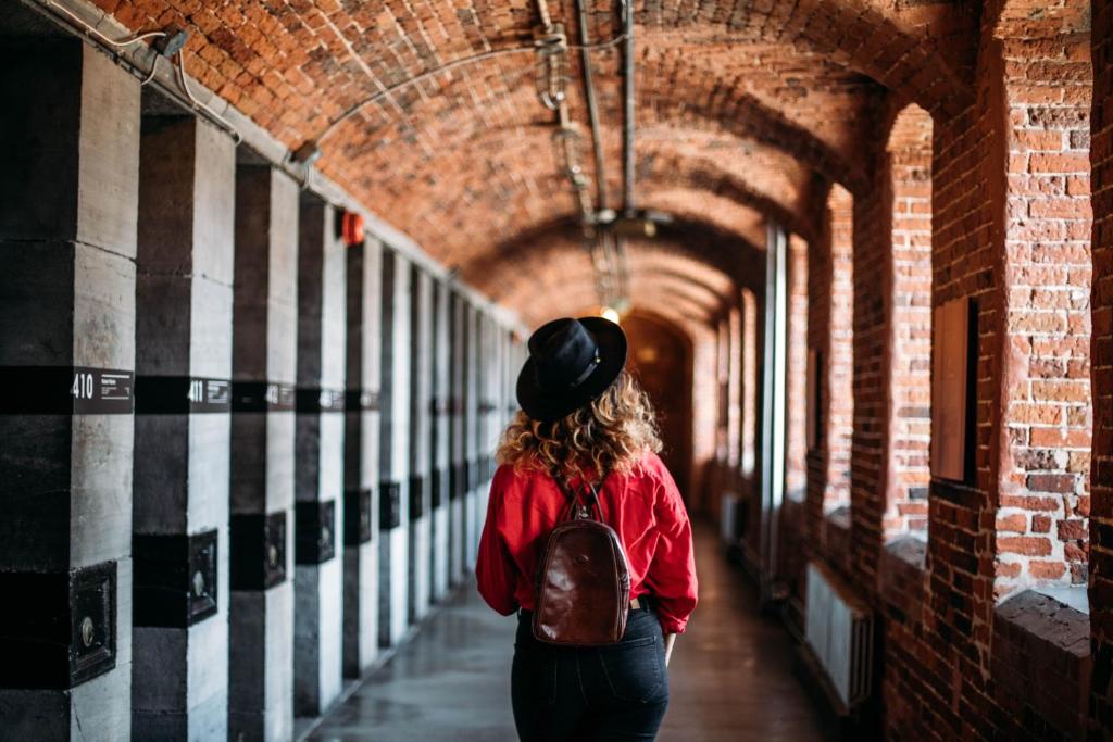 Una mujer en un sombrero caminando por un pasillo en Saintlo Ottawa Jail Hostel, en Ottawa