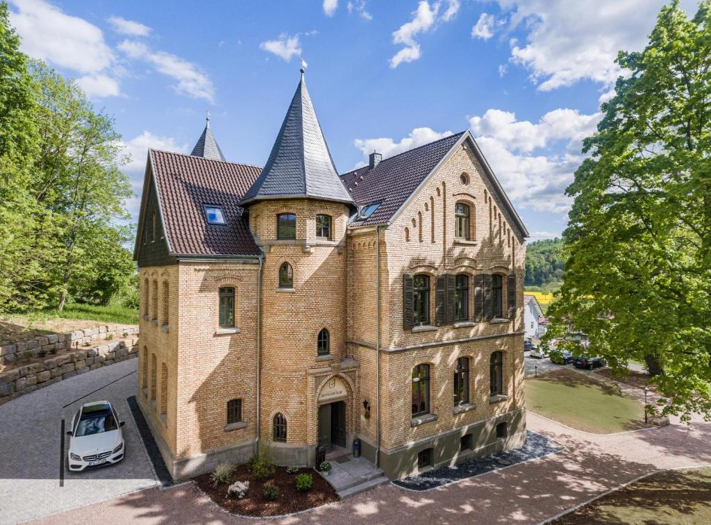 una casa vieja con un coche aparcado delante de ella en Villa von Boyneburgk, en Eisenach