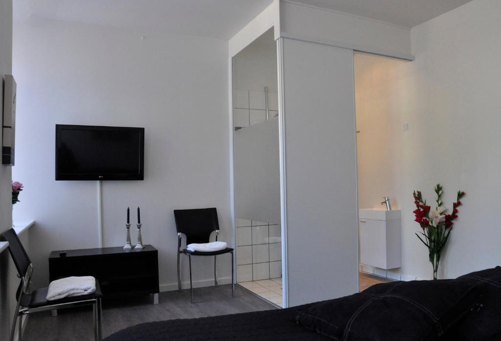 sala de estar con TV, sofá y silla en AB Centrum Aarhus Bed without Breakfast, en Aarhus