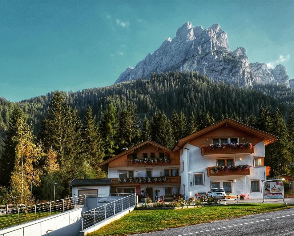 um edifício com uma montanha ao fundo em Residence Trenker Luis em Braies