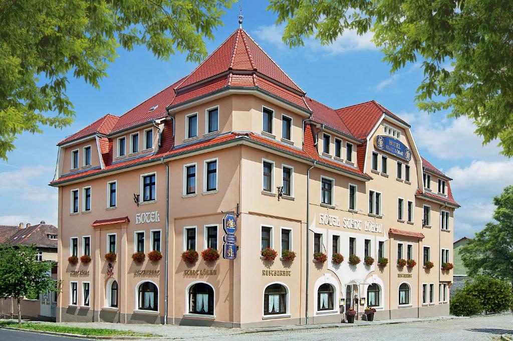 um grande edifício bronzeado com um telhado vermelho em Hotel Stadt Löbau em Löbau