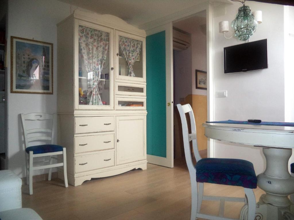 Cette chambre comprend une armoire blanche, une table et des chaises. dans l'établissement Casa Tella, à Venise