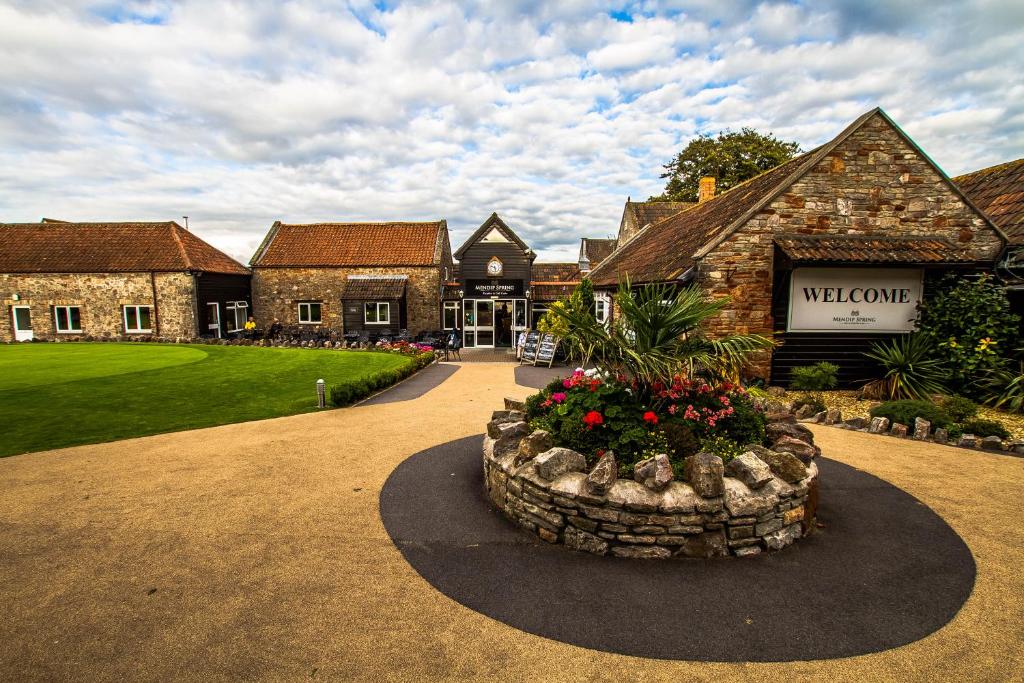 een huis met een grote tuin met een bloempot bij Mendip Spring Golf and Country Club in Churchill