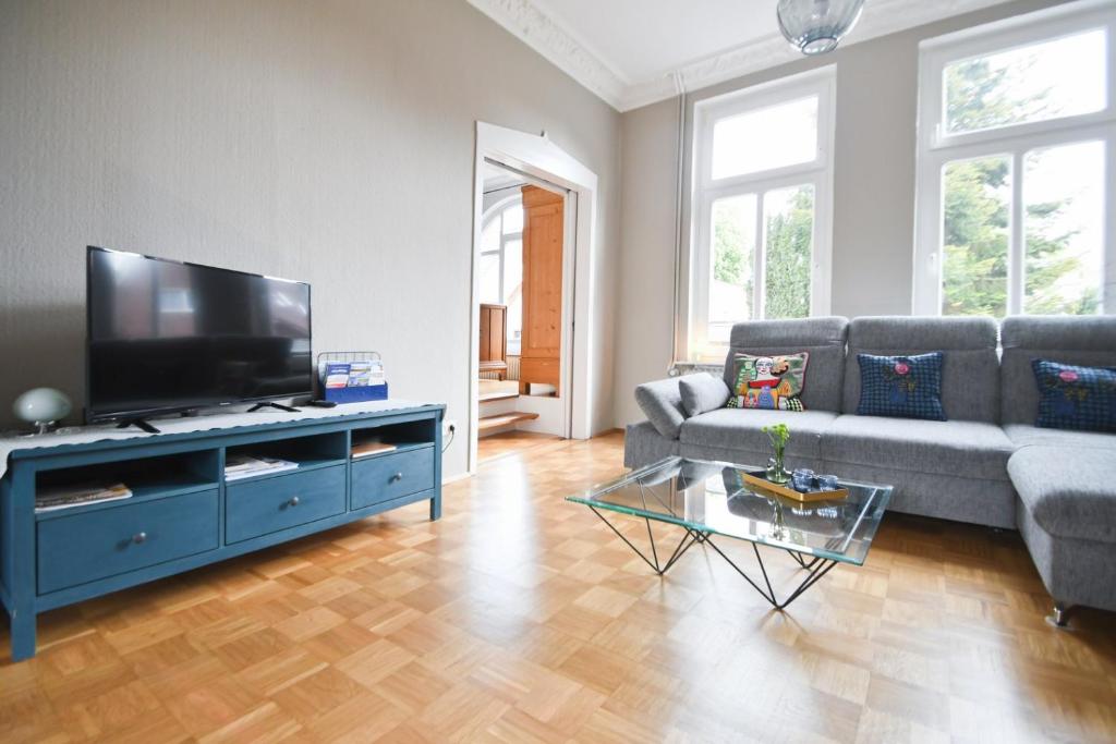 een woonkamer met een bank en een flatscreen-tv bij Stadtvilla Stöhr in Norden