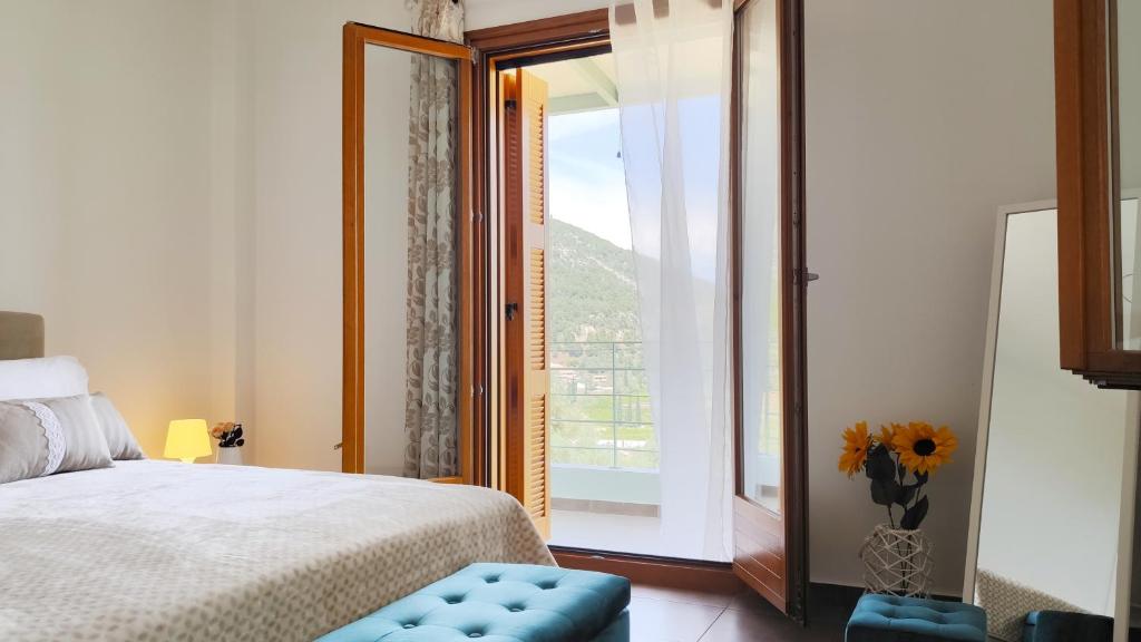 een slaapkamer met een bed en een groot raam bij Epidavros View Villas in Oud Epidauros