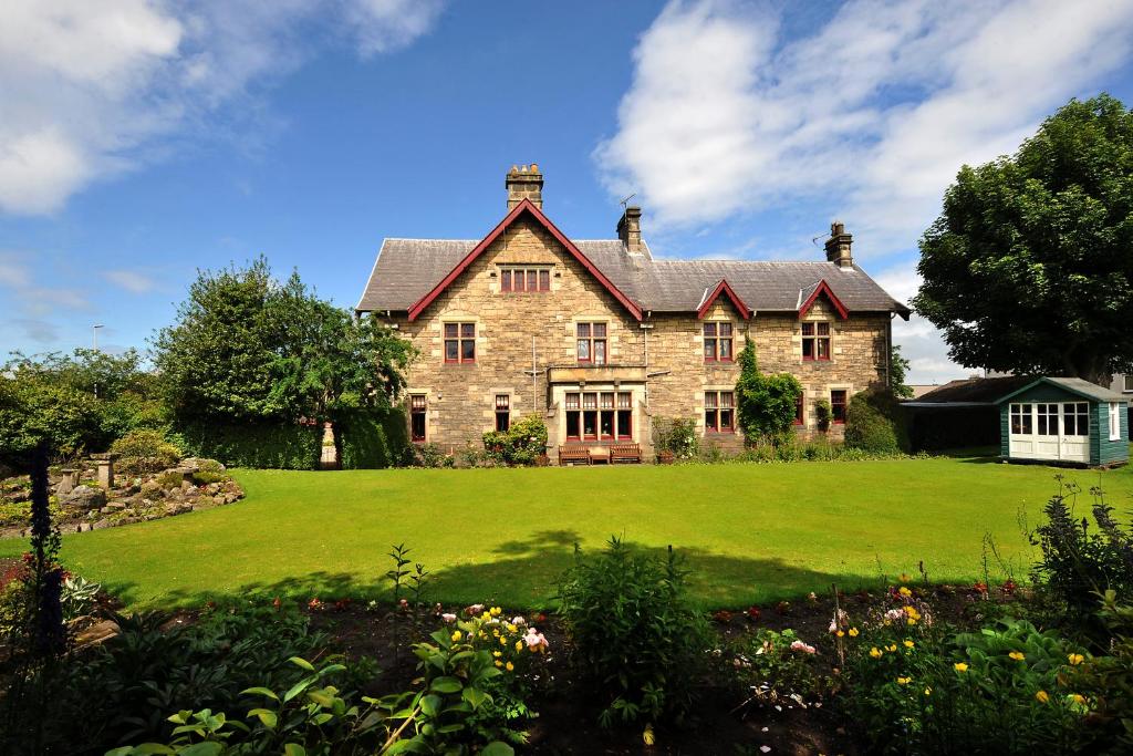 een groot bakstenen huis met een groot groen gazon bij St Michaels Guest House in Elgin