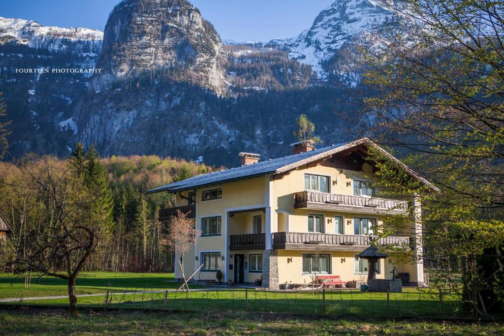 una grande casa con una montagna sullo sfondo di Landhaus Lilly a Obertraun