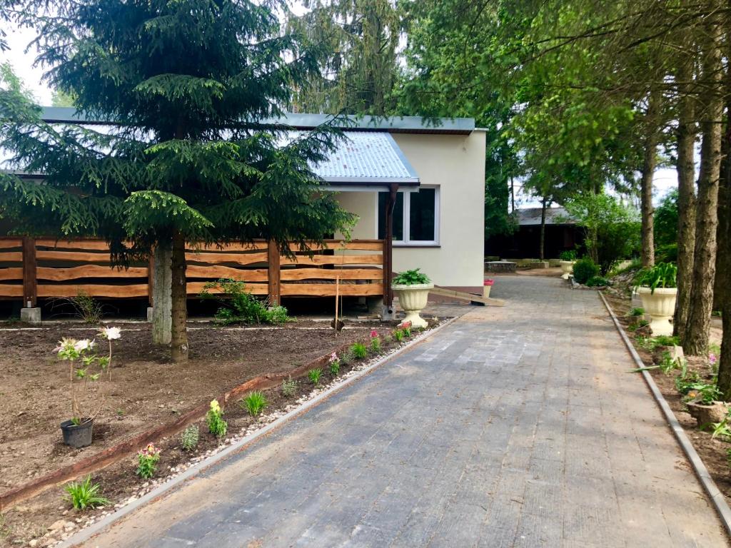 Ein Gehweg führt zu einem Haus mit einem Zaun. in der Unterkunft Stacja Wypoczynkowa Augustów in Augustów