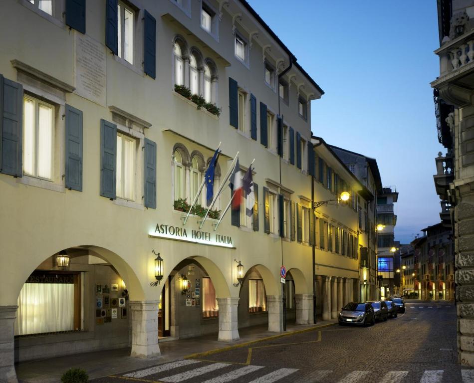 ein Gebäude mit Flaggen auf der Straßenseite in der Unterkunft Astoria Hotel Italia in Udine