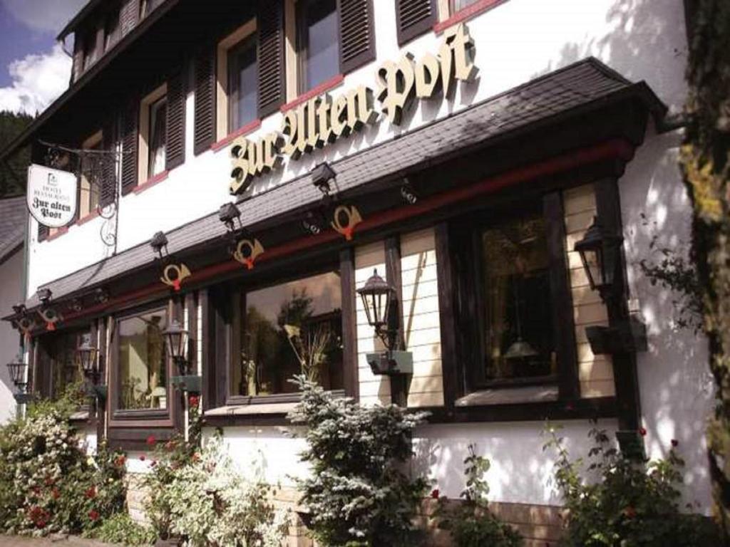 restauracja z znakiem na boku budynku w obiekcie Hotel Garni "Zur Alten Post" w mieście Willingen