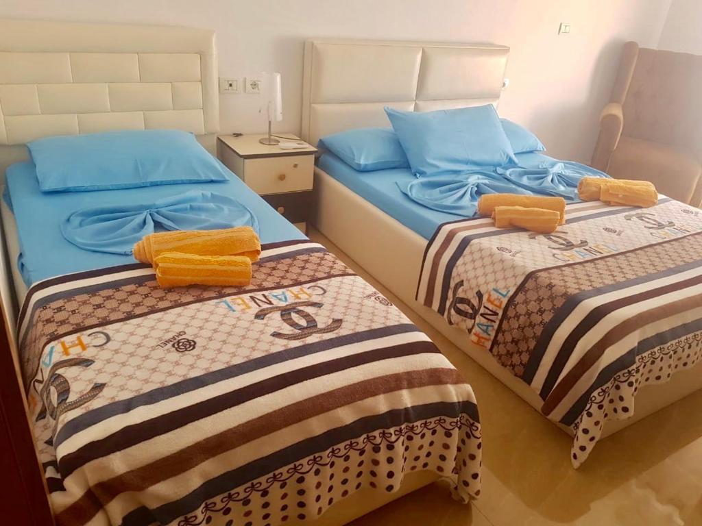 2 łóżka w małym pokoju z niebieską pościelą w obiekcie Sixth Apartment w Szkodrze