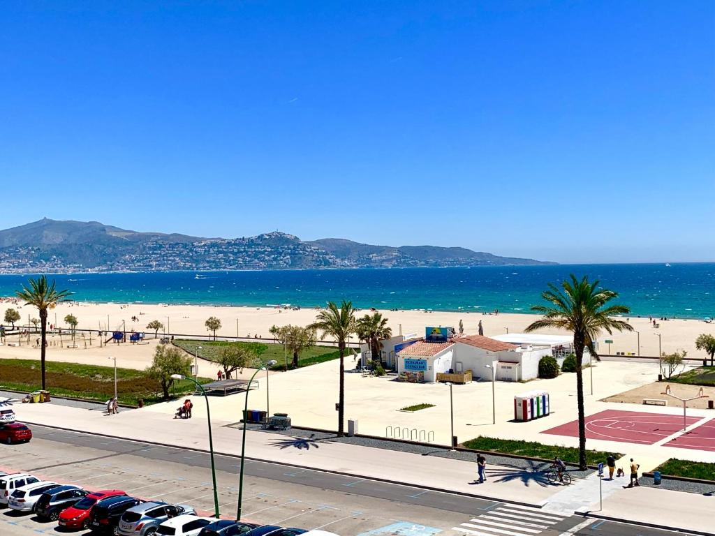 Blick auf den Strand und das Meer mit parkenden Autos in der Unterkunft Edifici Valeria in Empuriabrava