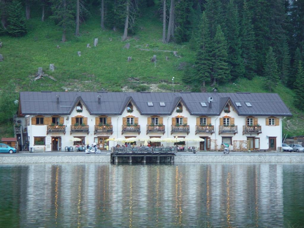 a large building on the shore of a lake at Quinz - Locanda Al Lago in Misurina