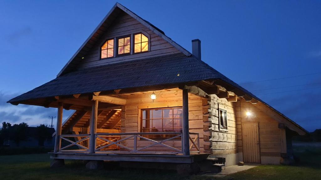 a log cabin with a thatched roof at Lāču namiņš/Bear house in Liepāja