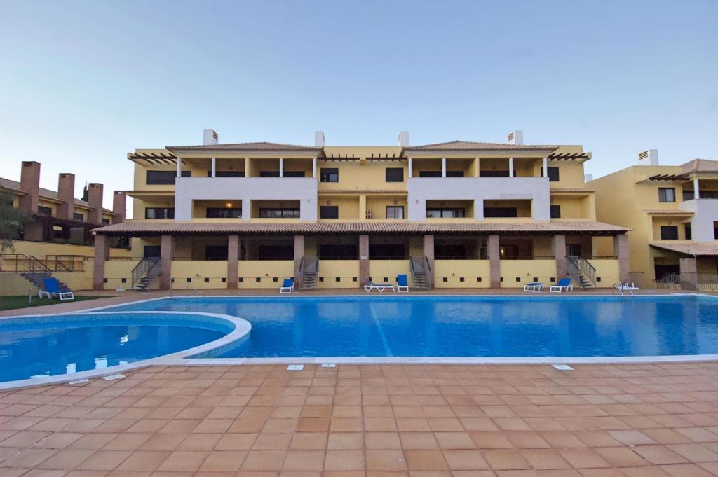 uma piscina em frente a um edifício em Vilamoura Condominio do Pinhal em Vilamoura