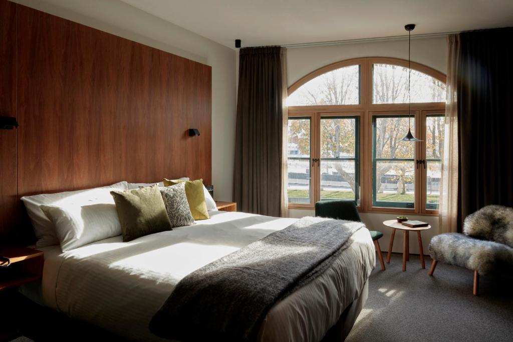 een slaapkamer met een groot bed en een groot raam bij Moss Hotel in Hobart