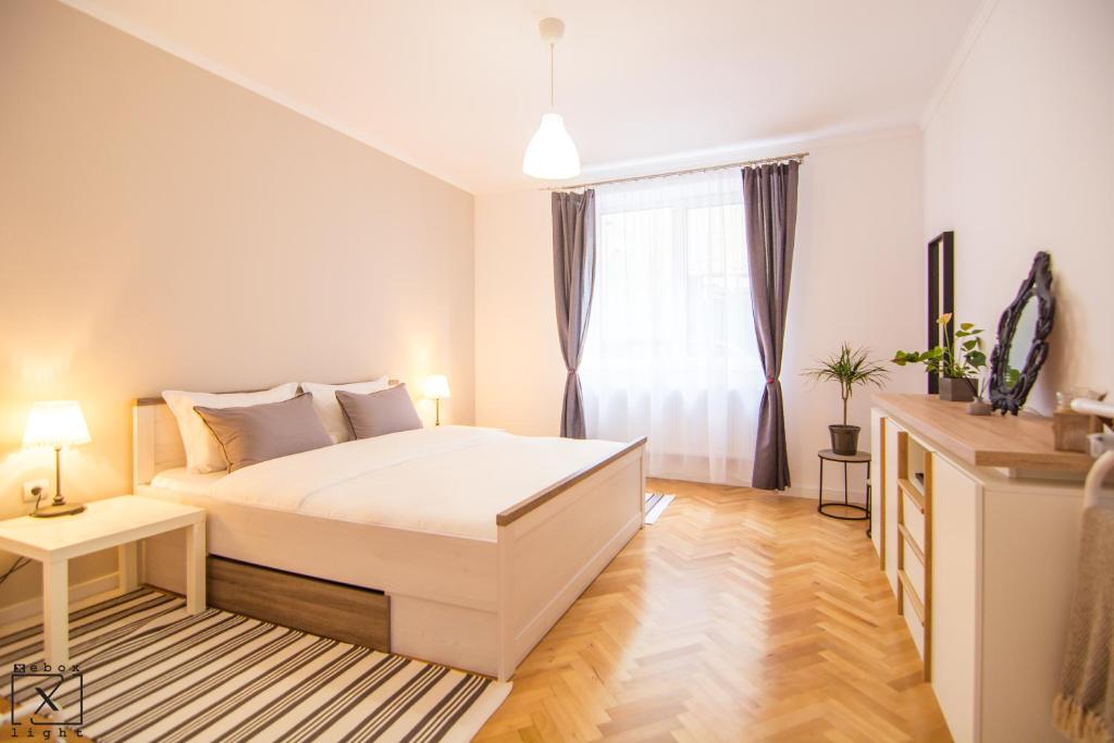 a bedroom with a white bed and a window at Via Del Centro in Sibiu