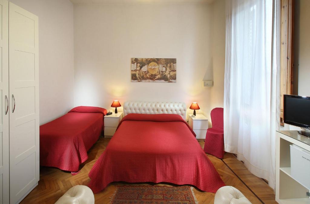 2 posti letto in una camera con lenzuola rosse di Hotel Internazionale a Montecatini Terme