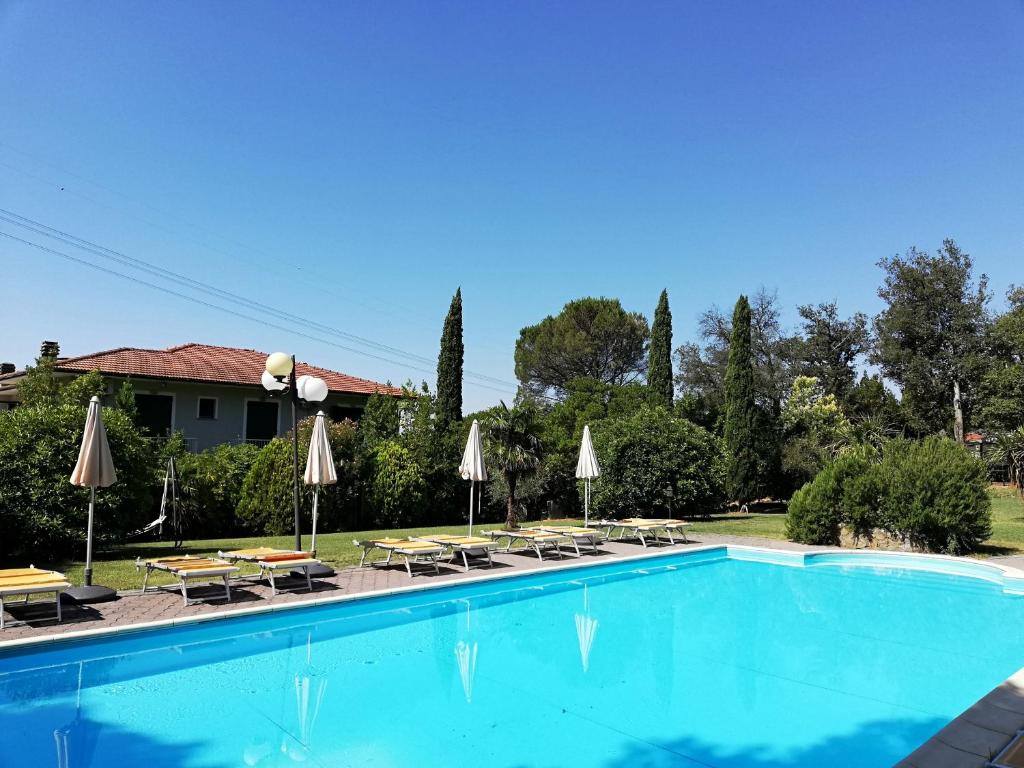 una piscina con sombrillas, mesas y sillas en Hotel Monti, en Lamporecchio