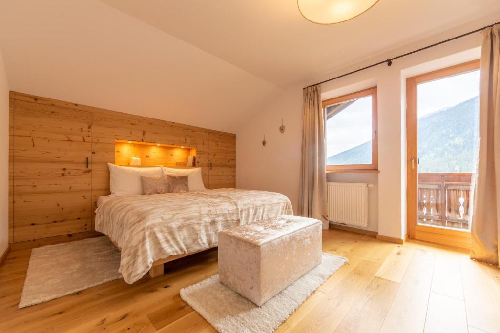 1 dormitorio con cama y ventana grande en Residence Tamperhof, en San Candido