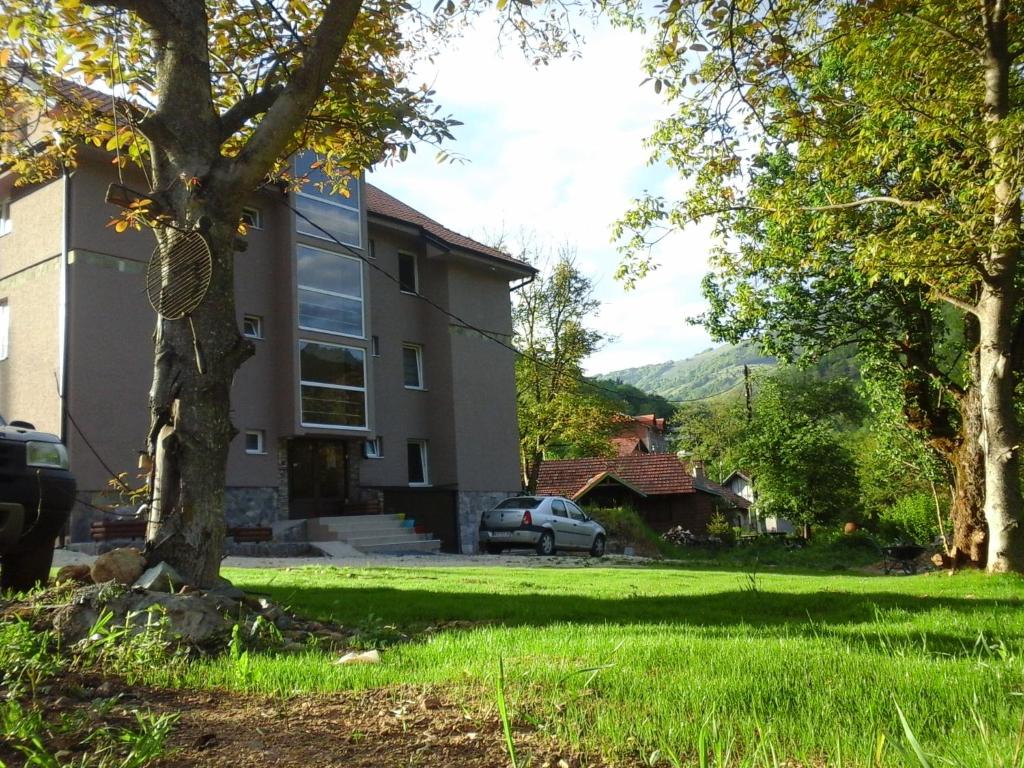 une maison avec un arbre dans la cour dans l'établissement BAJKA, à Crni Vrh