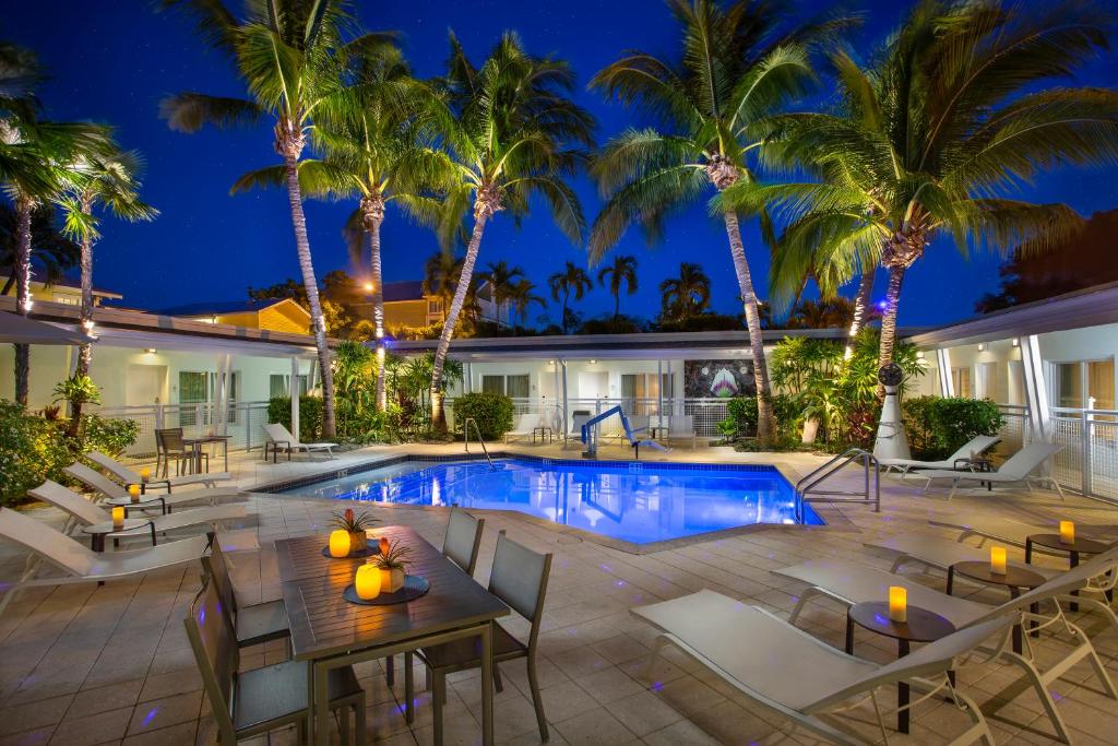 - une piscine avec des tables, des chaises et des palmiers dans l'établissement Orchid Key Inn - Adults Only, à Key West