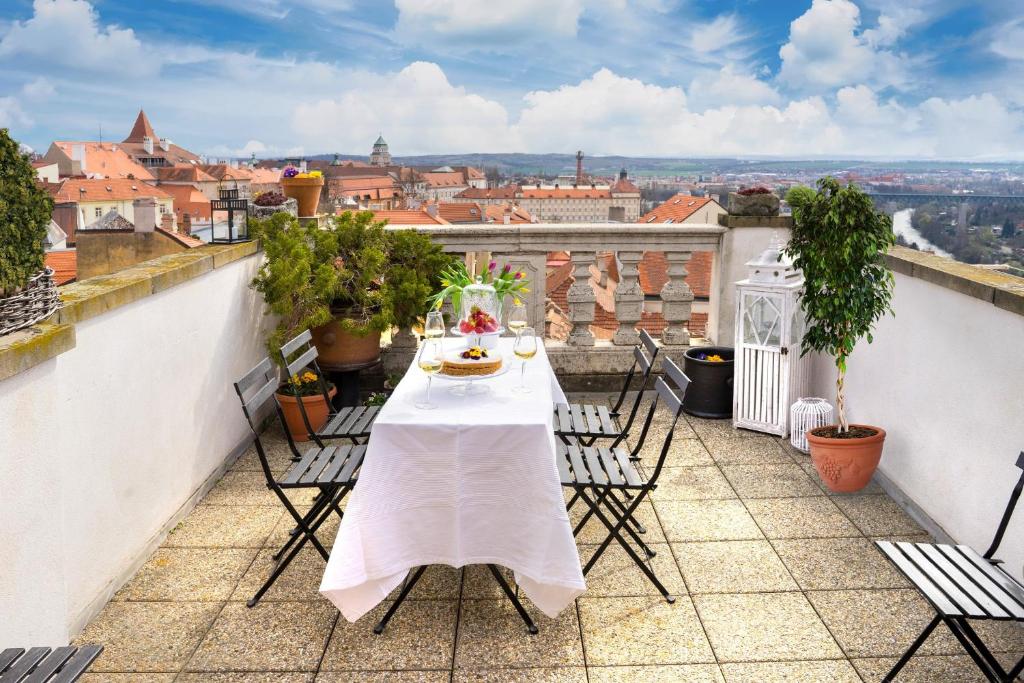 uma mesa numa varanda com vista para a cidade em Boutique Apartments U Rolanda, Mikulášské náměstí em Znojmo